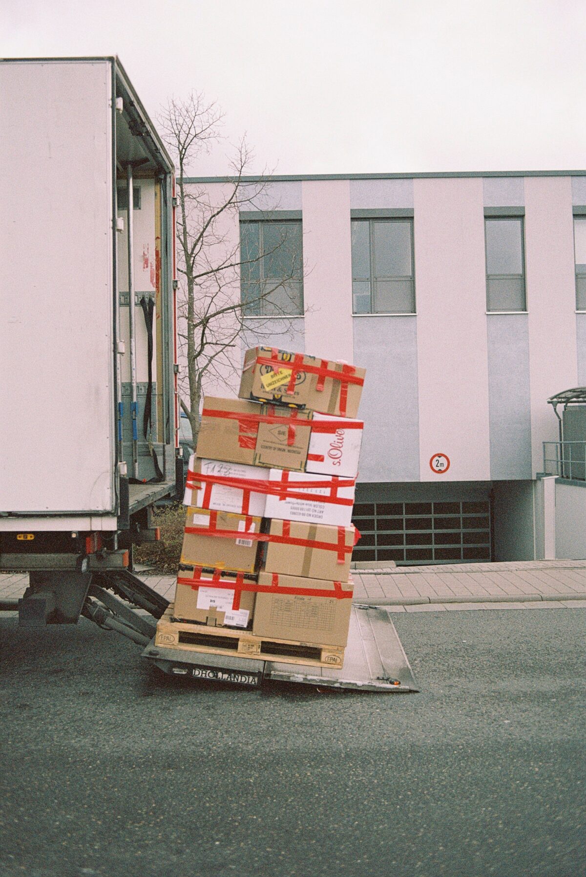 A picture of packed boxes kept on top of each other behind a parked truck